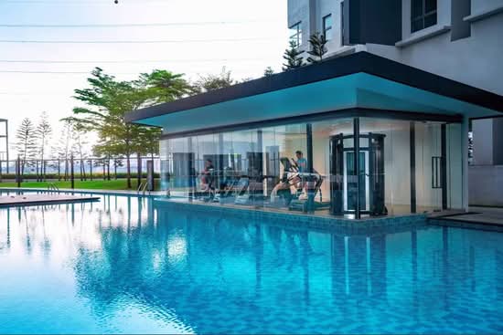 D'Rapport Residences glass-encased gymnasium overlooking the pool